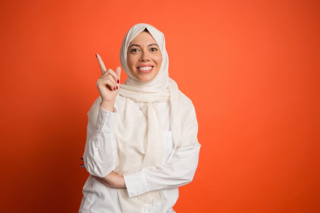 happy arab woman hijab portrait smiling girl posing red studio background min scaled